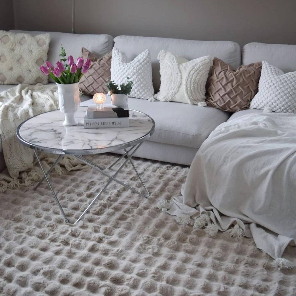 En bubblig textur som matta under soffa i vardagsrum skapar liv genom form och vacker beige färg.