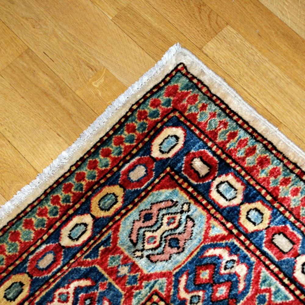 Handvävd matta med orietaliska mönster och fina färger i rött, blått, grönt och gult.