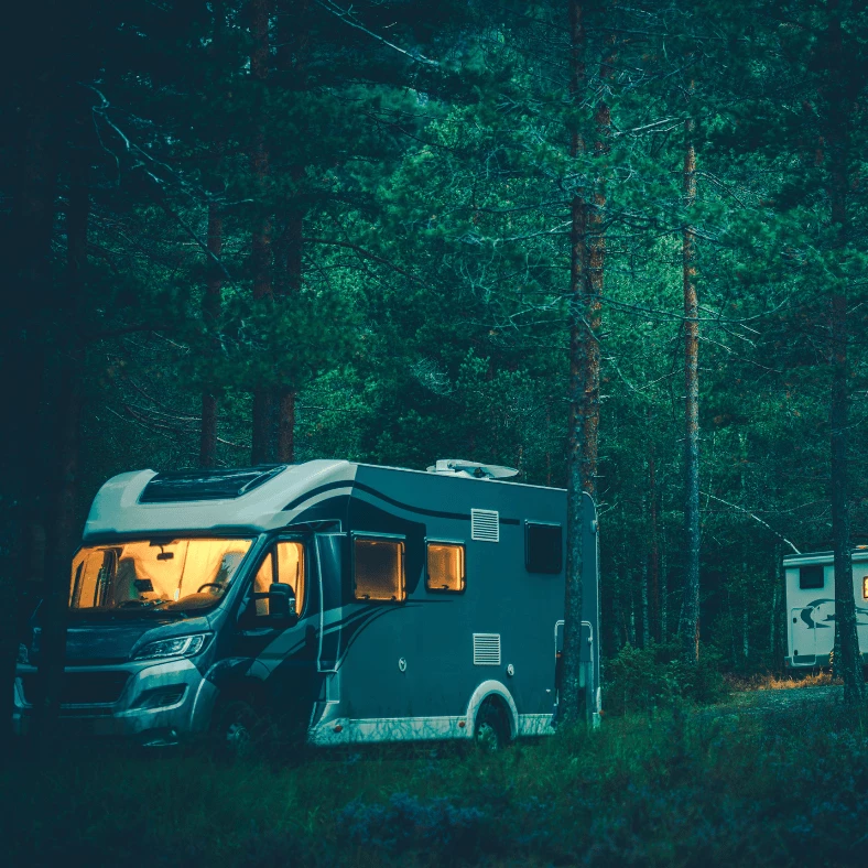 Husvagn & husbil i skogen. Varm & mysig atmosfär i fordonet. Mörkt och kyligt utanför. Vacker kontrast.