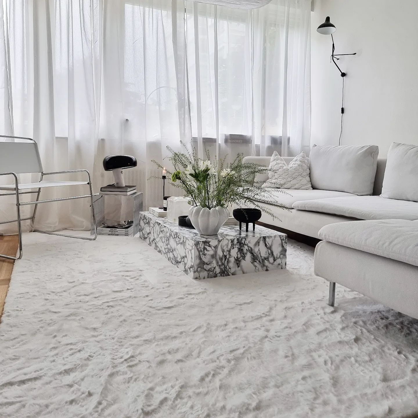 Vit polyester matta i mjuk & fluffig textur i vardagsrummet under soffa och soffbord.