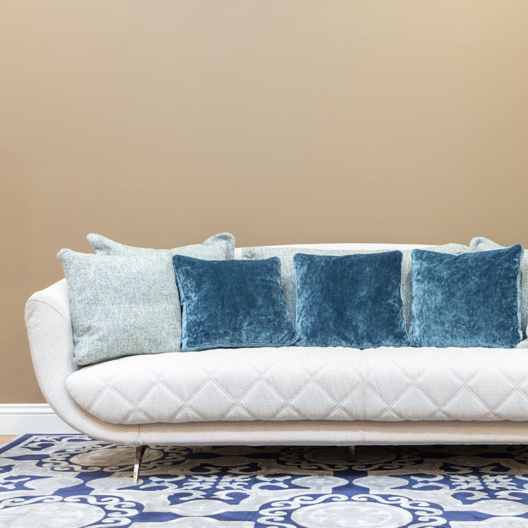 Blå mönstrad matta till vit soffa i modernt vardagsrum i minimalistisk inredningsstil.
