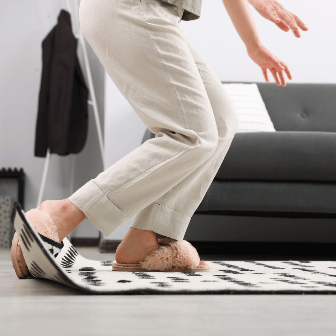 Person halkar på en matta utan glidksydd. Detta kan förhindras med en halkfri matta från SE Mattor.