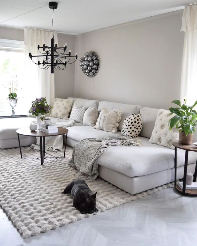 Vacker matta under ljusgrå soffa i vardagsrum med ljus och öppen inredning.