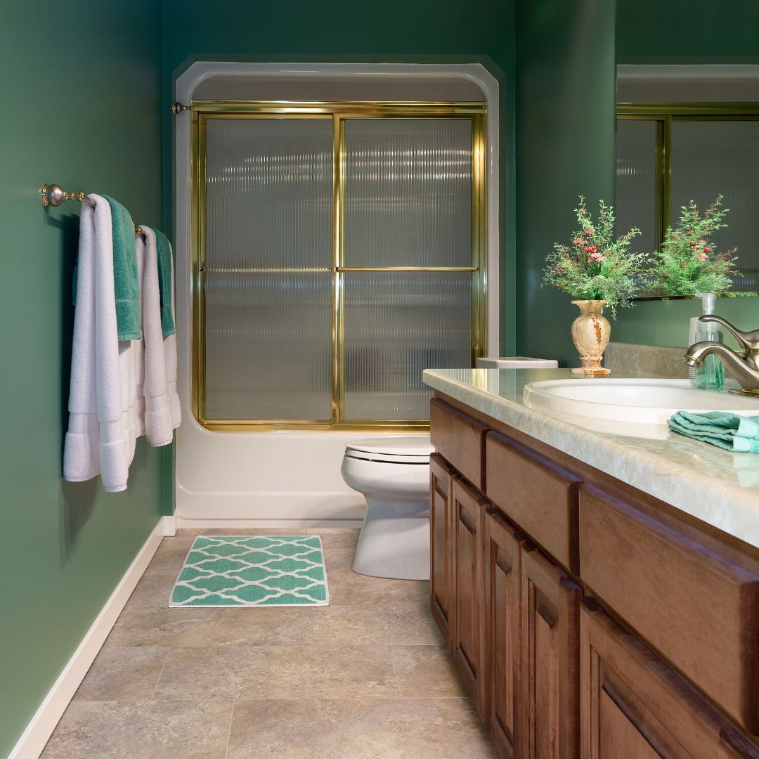 Badrumsmatta inspiration i ett elegant grönt badrum. I badrummet utmärks en liten grön och vit mönstrad badrumsmatta, perfekt för trånga och små badrumsutrymmen.