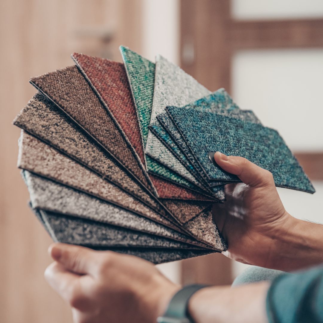 Person har provexemplar på tygbitar inför val av färg till matta för att förstå färgpsykologi hos mattors färg.