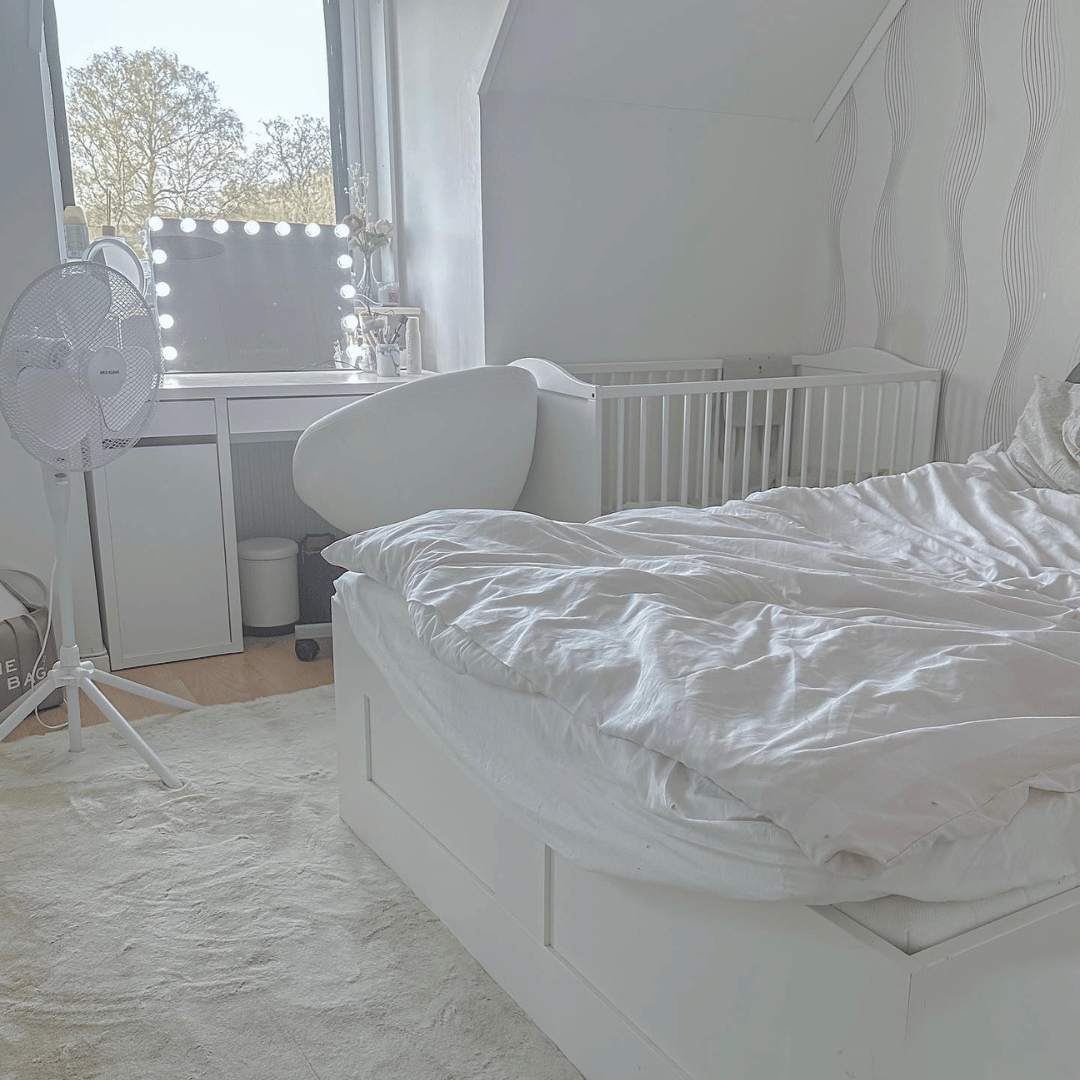 Vit ryamatta i vitt rum under en vit säng med vita sängkläder.