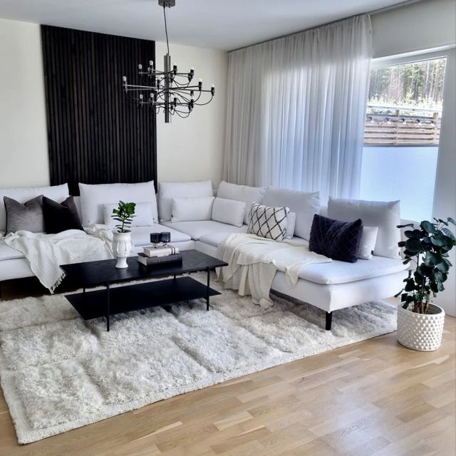 Vit matta till vit hörnsoffa i stort vardagsrum i klassisk stil.