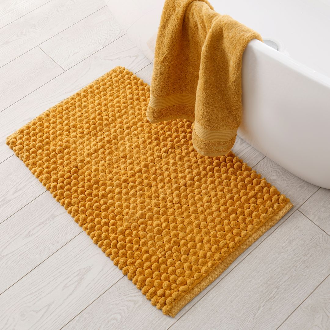 En mjuk badrumsmatta i gul pastellfärger som ger en varm känsla till ditt badrum.