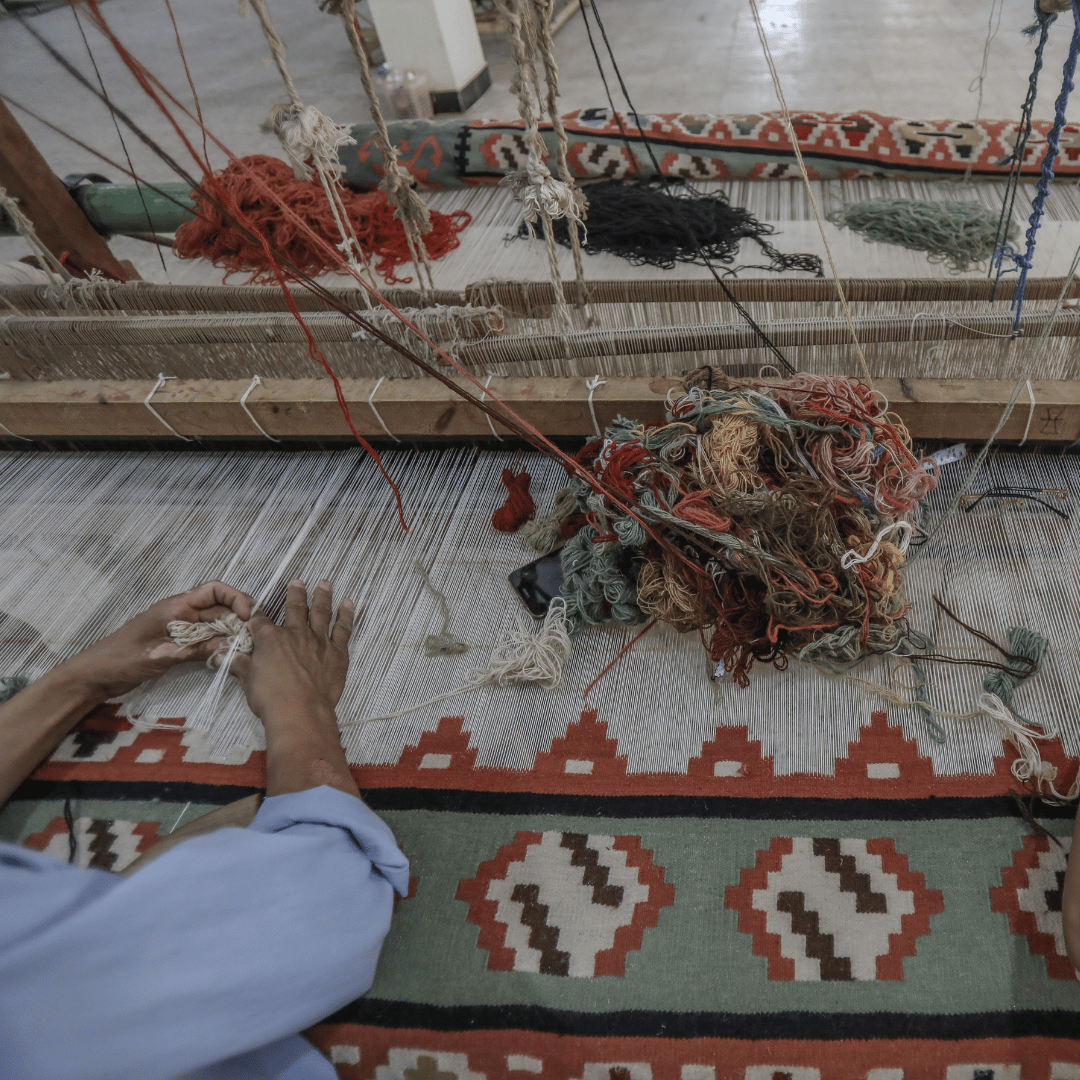 Tillverkning av handknutna mattor med människor som arbetar med händerna.