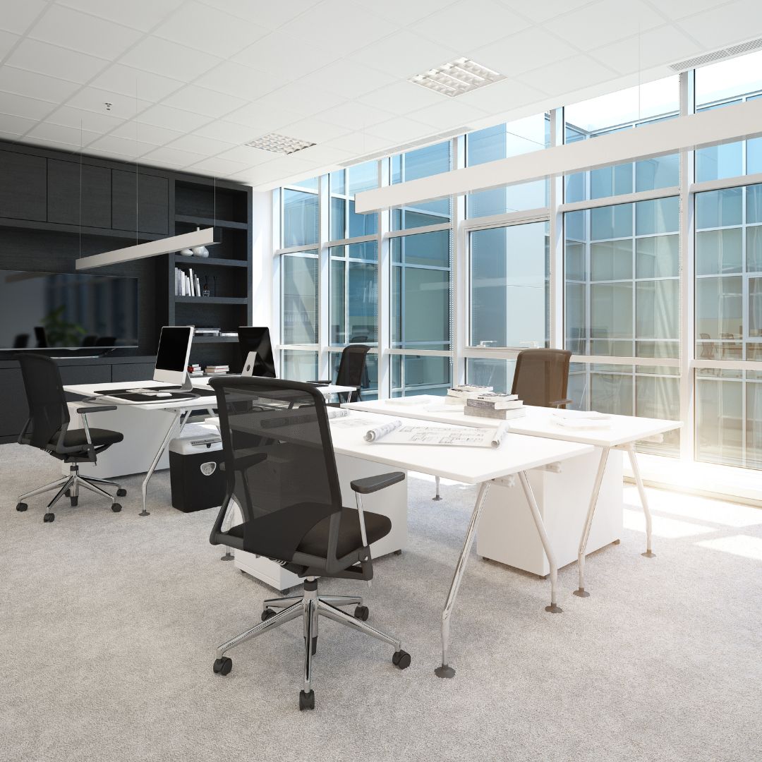 Kontorsmiljö med en stor ljusgrå matta som gör det ombonat i kontoret.