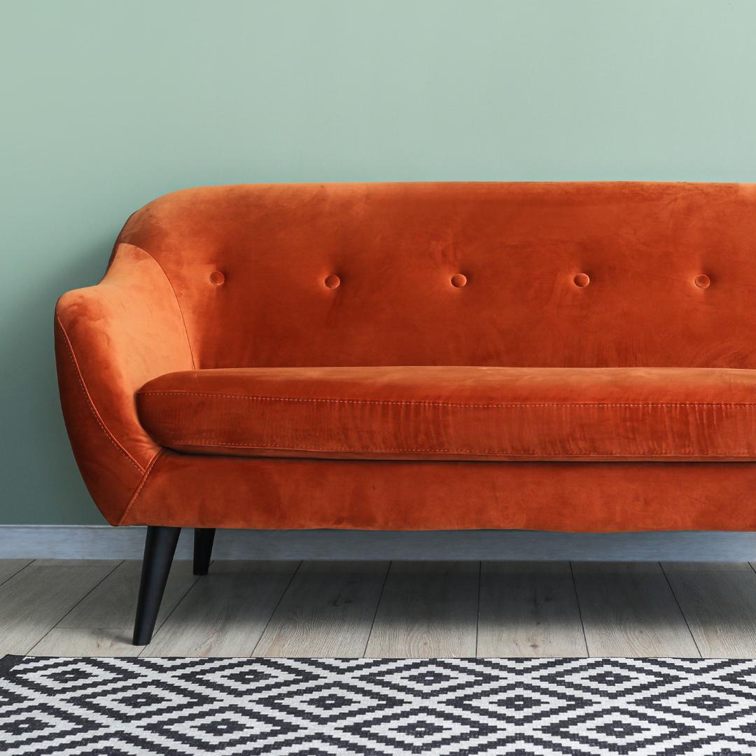Mönstrad matta till orange soffa i ett litet vardagsrum med färgglad stil.