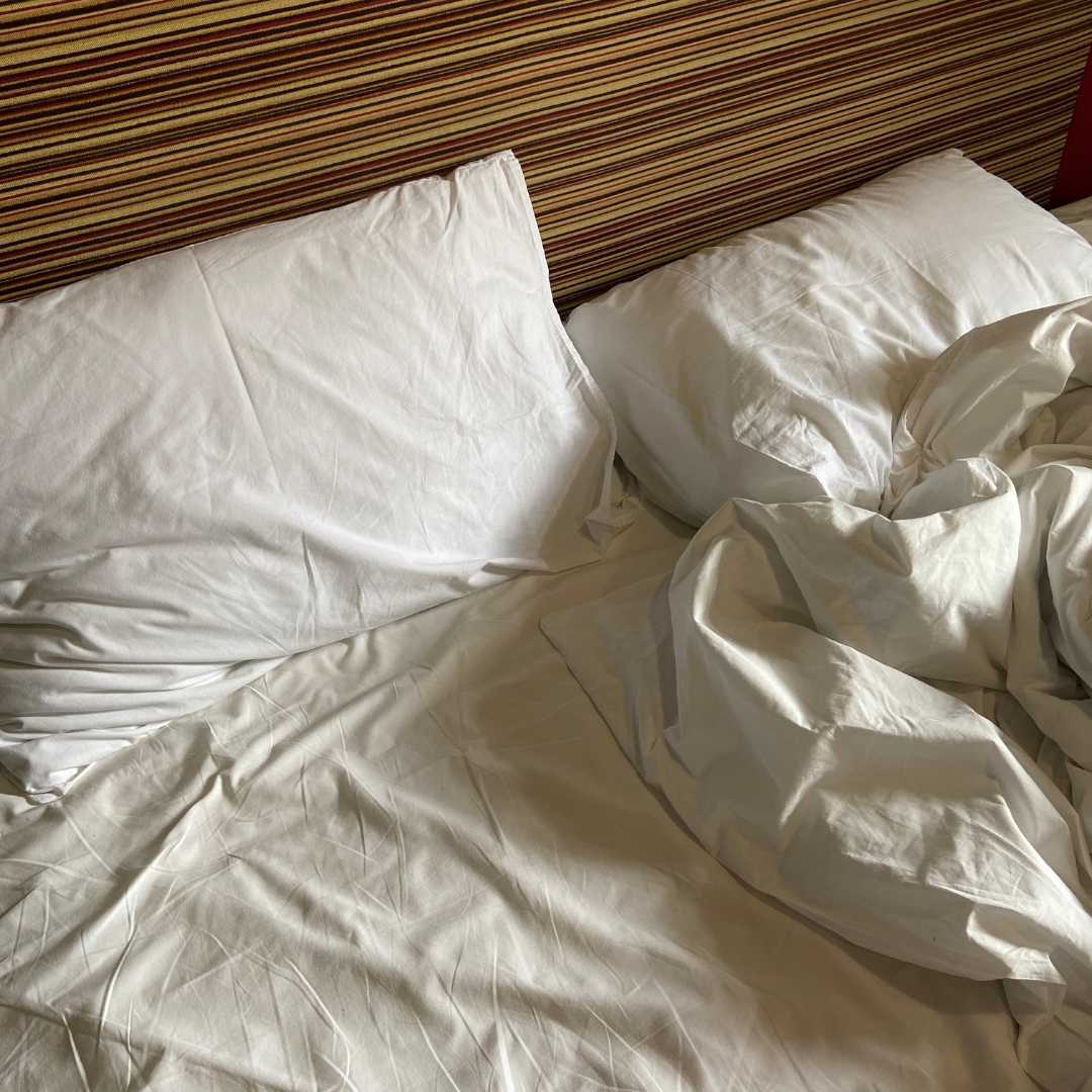 Smutsig kuddfodral på säng som behöver tvättas ren.