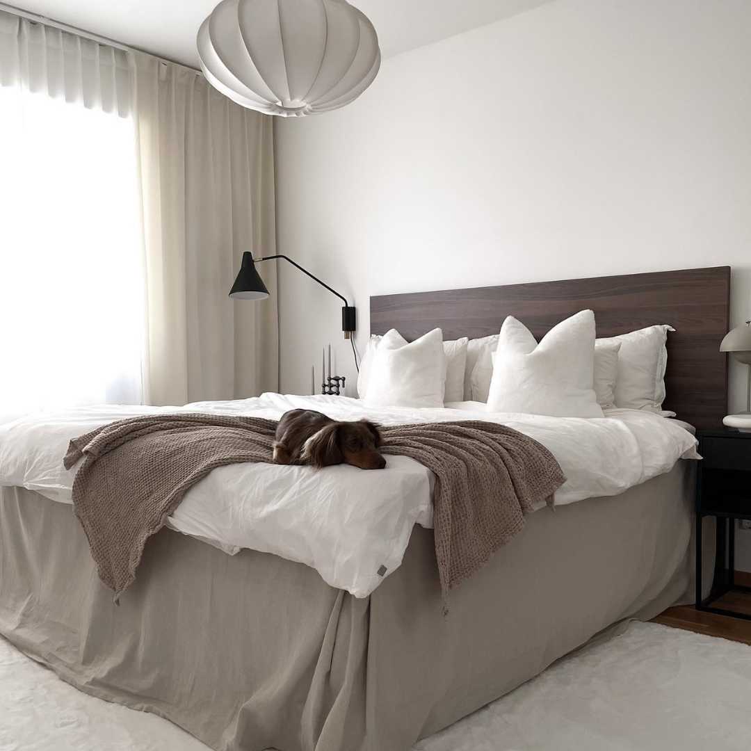 Vacker sovrum i japandi inredning med nytvättade sammetsgardiner i beige och vit färg.