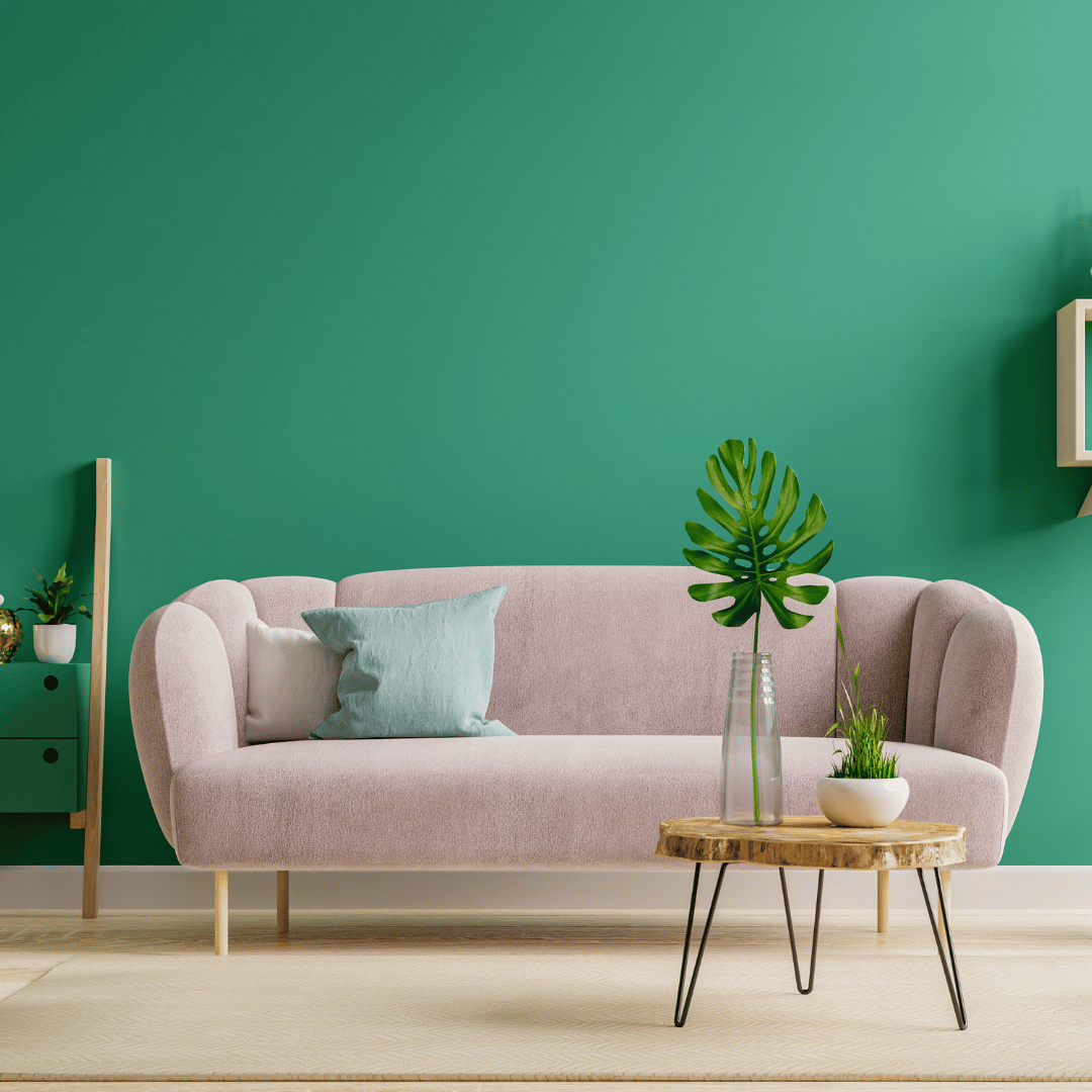 Rosa soffa med bekväm matta under i unikt vardagsrum med gröna väggar.
