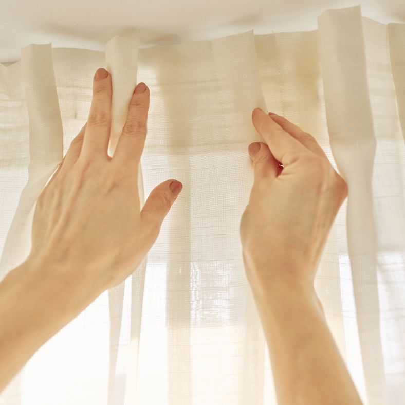 Händer ser till att gardinerna hänger jämnt.