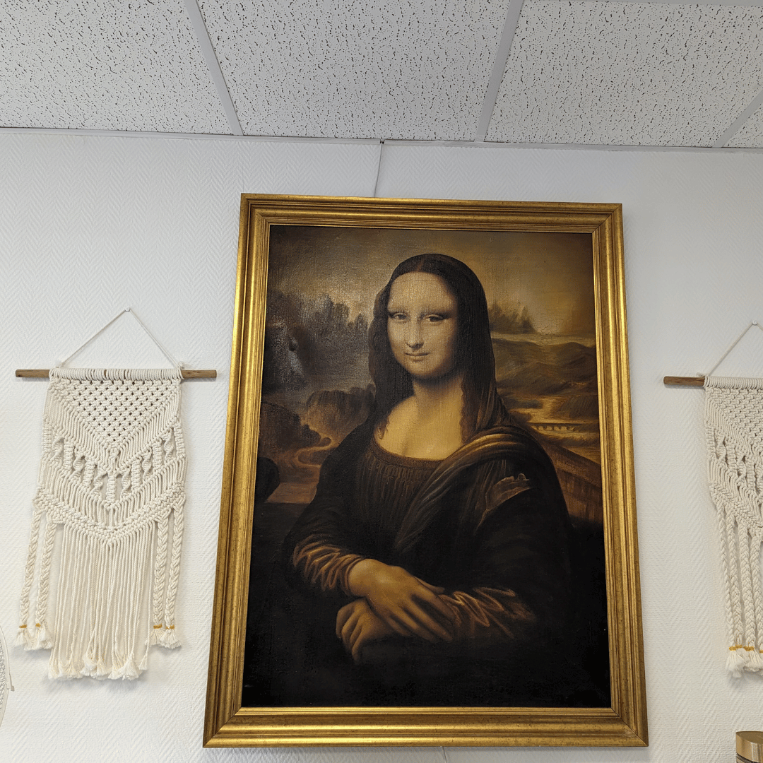 Matta på väggen bredvid en stor tavla av Mona Lisa.